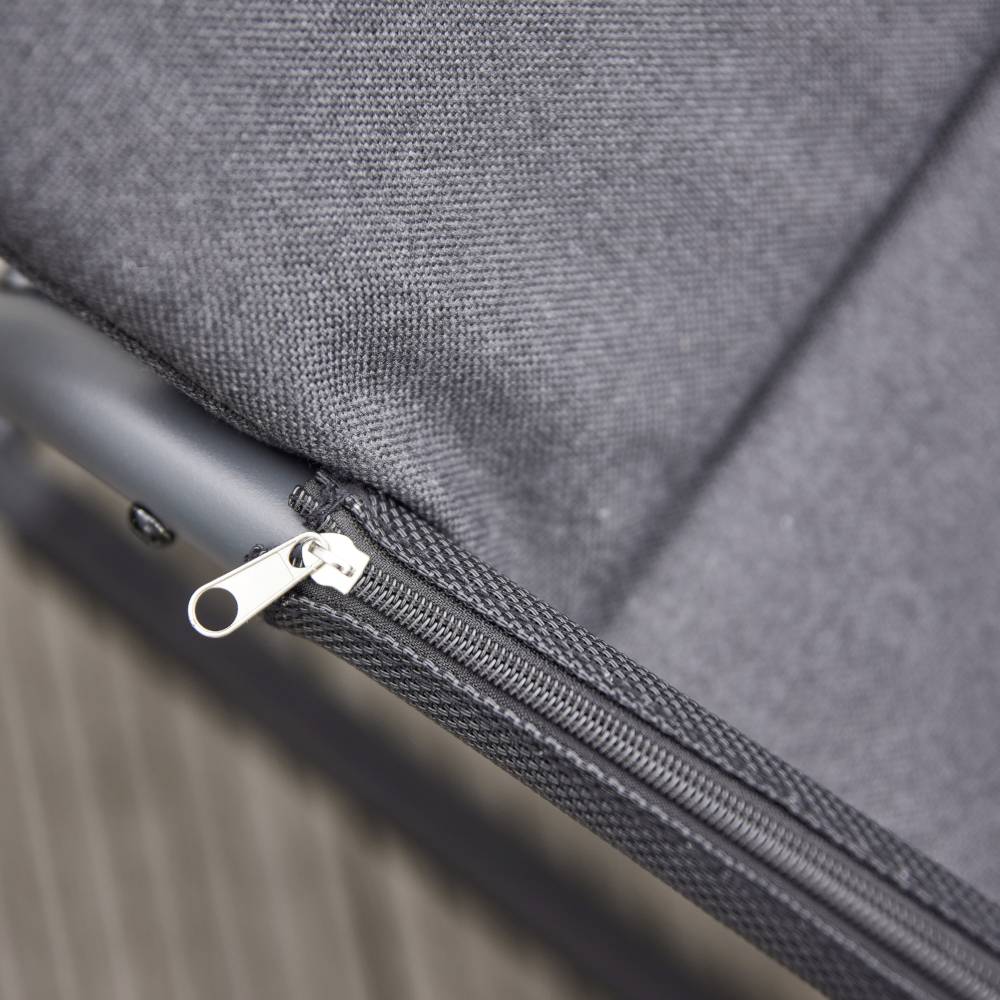 Schwarzes Stoffgewebe mit einem nahen Blick auf einen Reißverschluss an der Kante, möglicherweise Teil eines Möbelstücks oder einer Tasche.