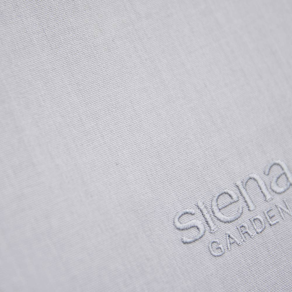 Hellgrauer Stoff mit feiner Textur, darauf das Logo 'siena GARDEN'.