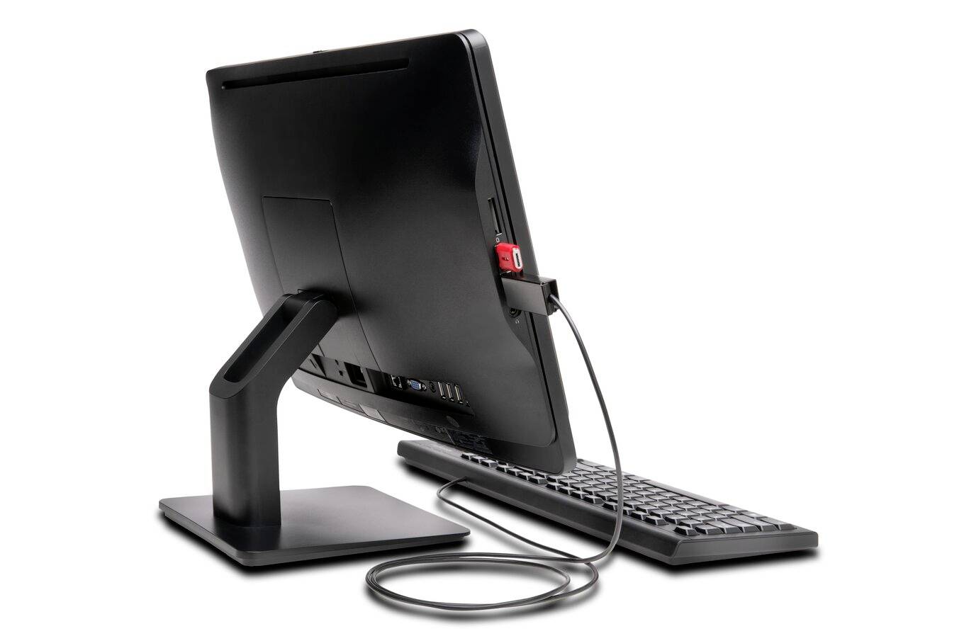 Ein schwarzer Monitor mit angeschlossener Tastatur und USB-Stick auf der Rückseite. Der Monitor steht auf einem Tisch.