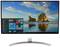 Ein Computermonitor zeigt den Desktop von Windows mit geöffnetem Startmenü vor einem Strandhintergrundbild mit Felsen im Meer.