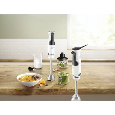 Zwei Stabmixer auf einer Küchenarbeitsfläche mit einer Schüssel Suppe, einem Glas Mixer und einem Glas mit grünem Püree.