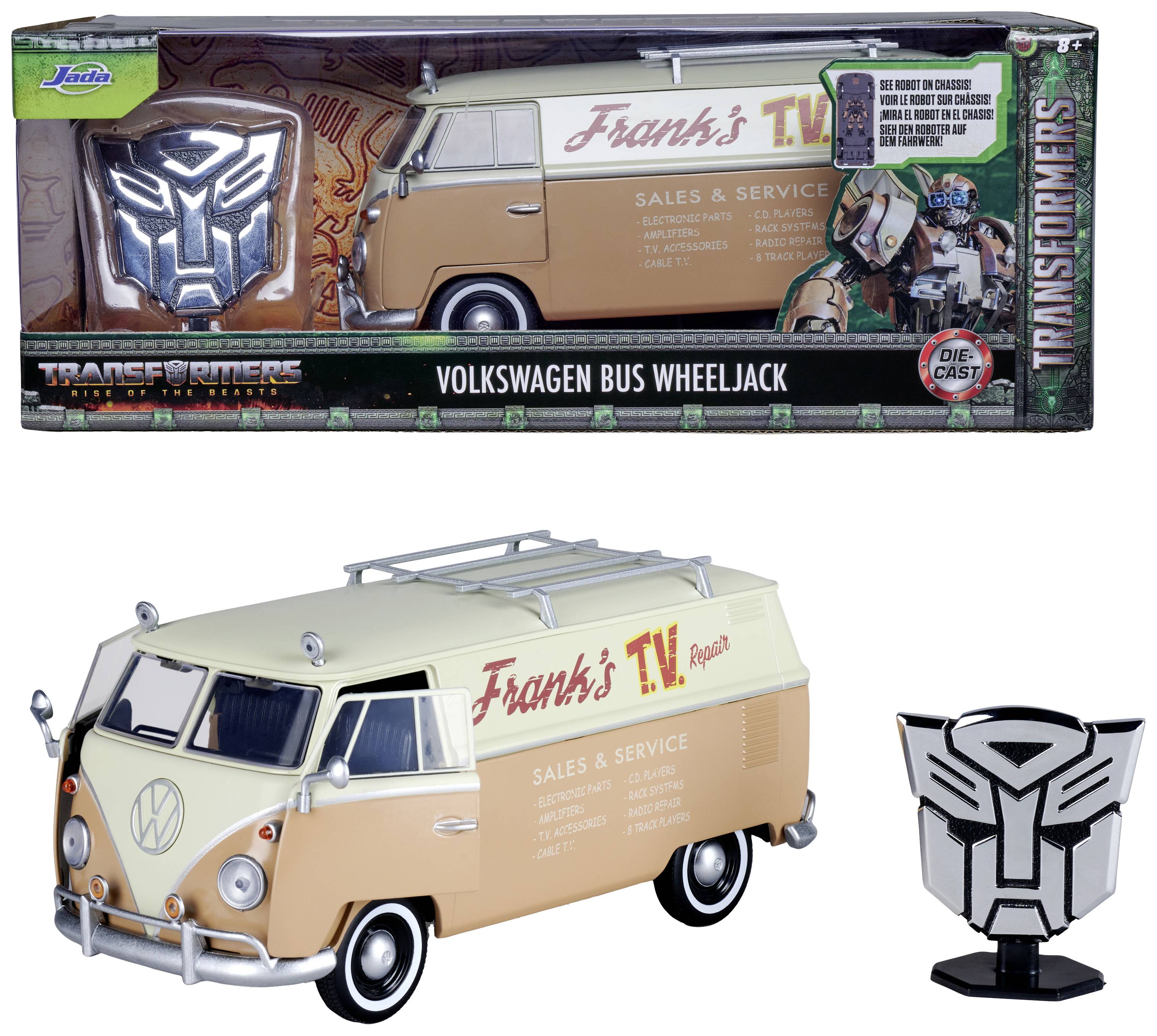Modell eines Volkswagen-Busses mit 'Frank's TV Repair'-Aufschrift, in 'Transformers'-Verpackung, neben einer Metall-Plakette.