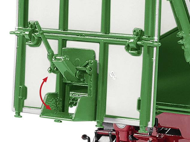 Grüne Mechanikstruktur mit Hebel und rotem Pfeil zeigt Bewegungsrichtung. An Fahrzeug montiert, Detail eines Laderampensystems.