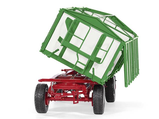 Anhänger mit grünem, schwenkbarem Container auf roten Rädern, gekippt nach links, zeigt mechanische Funktionen.