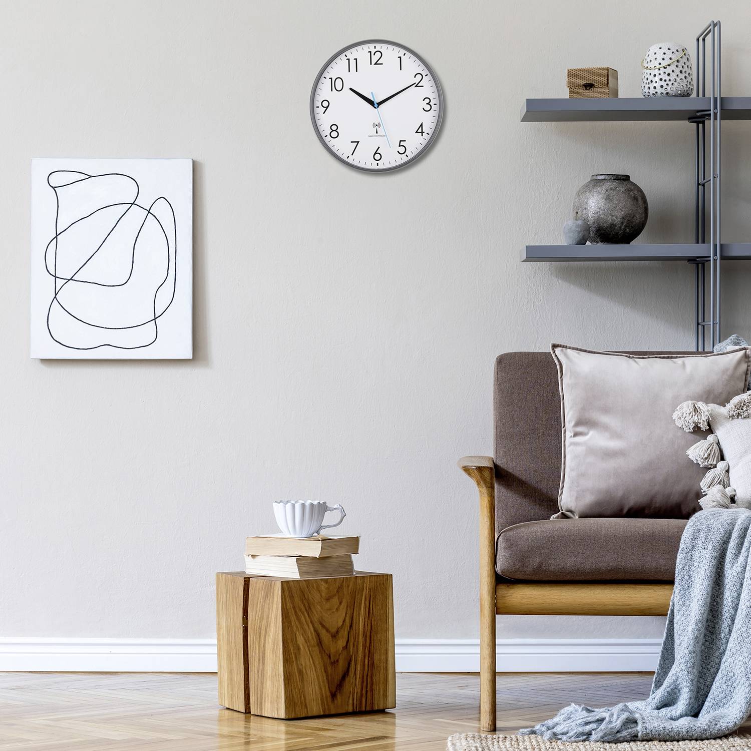 Ein stilvoll eingerichtetes Wohnzimmer mit einem braunen Sessel, einem Holztisch, einem modernen Kunstwerk an der Wand und einer Wanduhr.