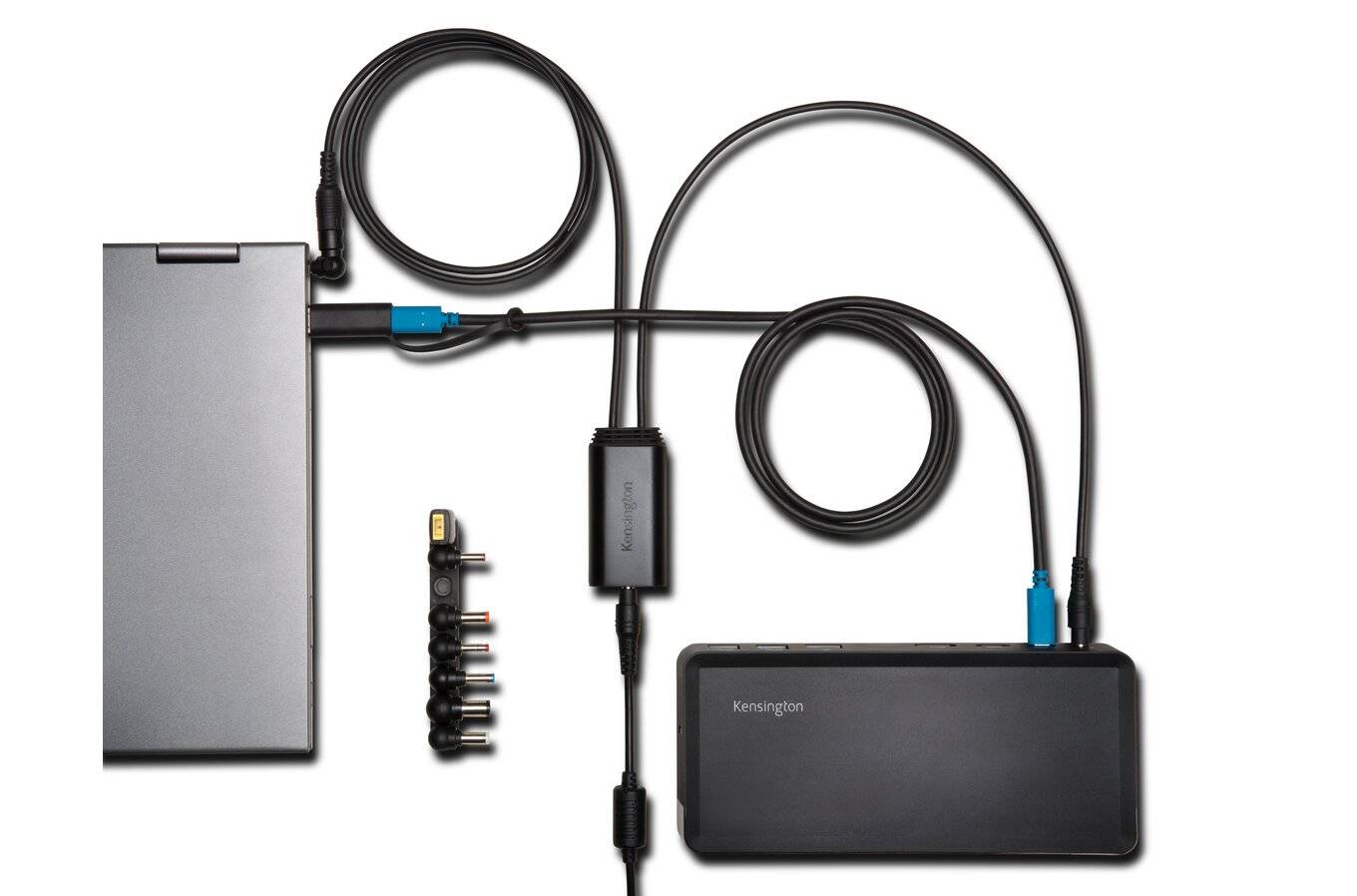 Mehrere elektronische Geräte verbunden durch Kabel mit Adaptern und einem Kensington-Gerät; zeigt eine technologische Verkettung.