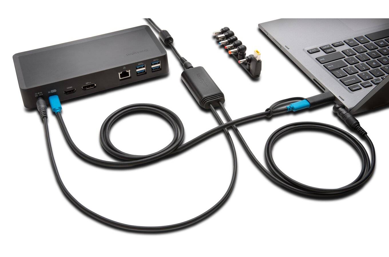 'Laptop angeschlossen an eine Dockingstation mit mehreren Kabeln und Anschlüssen; zeigt Verbindungen für USB, HDMI und Ethernet.'