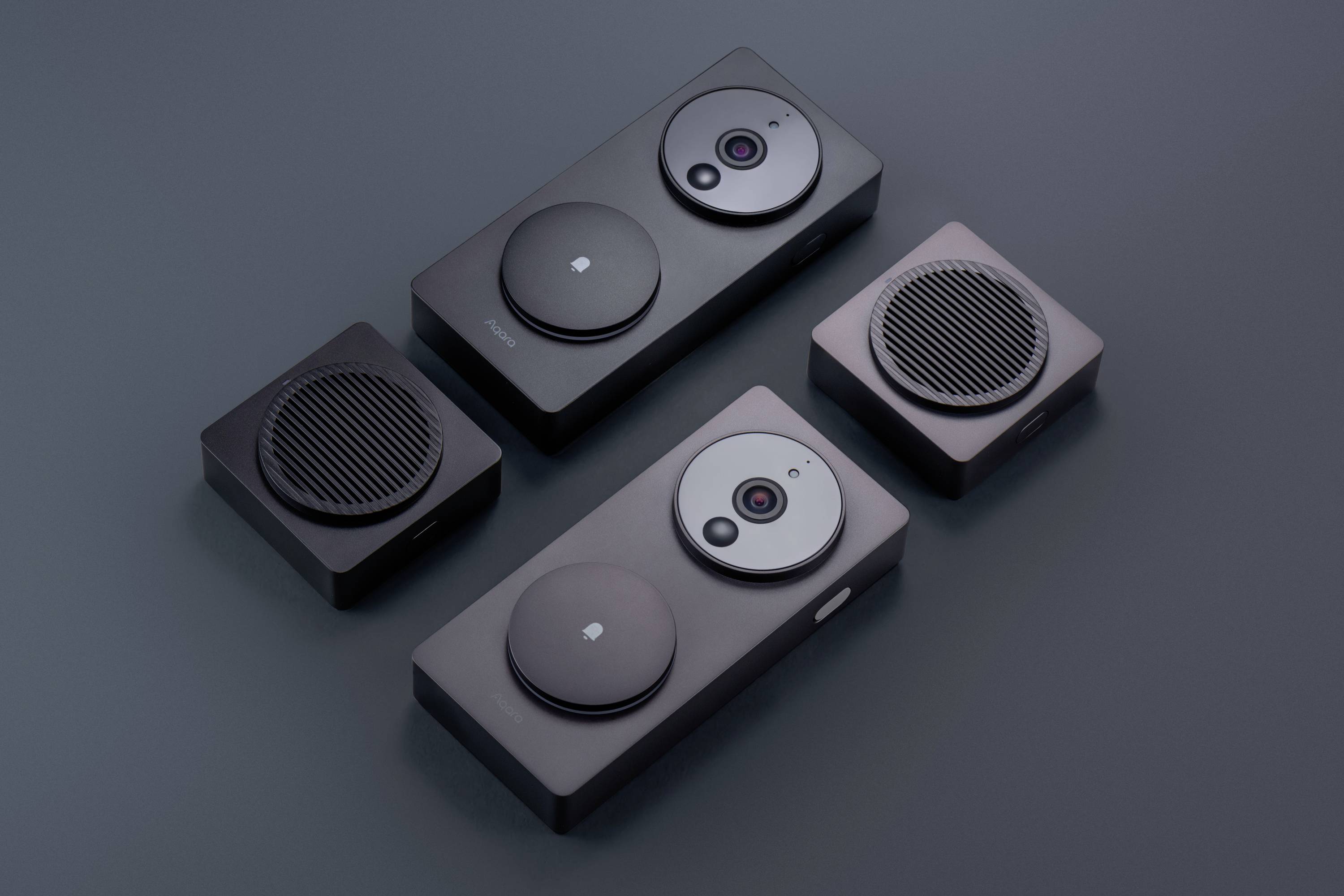 Eine Auswahl von vier modernen, grauen Überwachungskameras unterschiedlicher Größe auf dunkler Oberfläche.