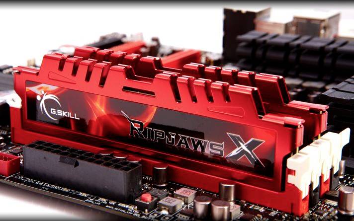 Rote G.Skill Ripjaws X RAM-Module mit auffälligem Design auf einem Computer-Motherboard montiert, mit Details im Hintergrund.
