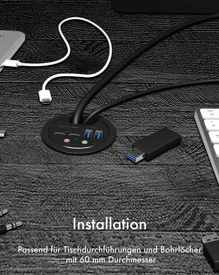 Eine Tischsteckdose mit Anschlüssen und USB-Ports ist in eine Tischplatte eingebaut. Der Text lautet: 'Installation: Passend für Tischdurchführungen und Bohrlöcher mit 60 mm Durchmesser'.