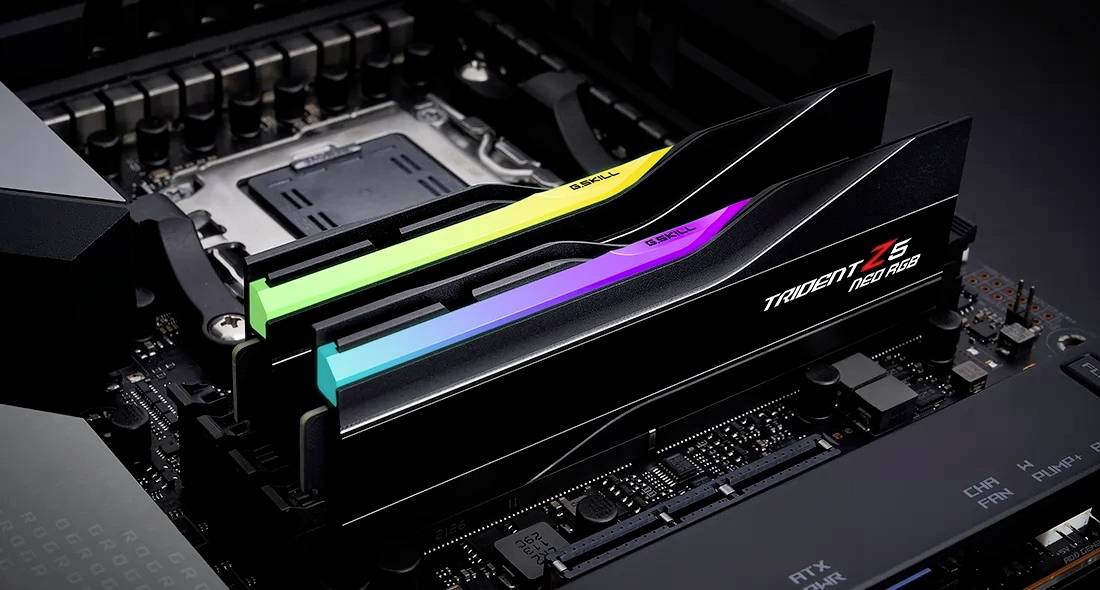 Zwei RAM-Module auf einem Motherboard, beleuchtet in Regenbogenfarben. Die Module sind von einer Marke mit dem Namen 'Trident Z5'.
