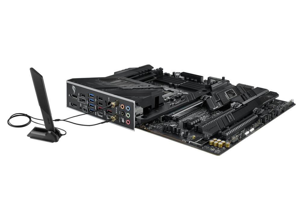 Ein schwarzes Motherboard mit mehreren Anschlüssen, darunter USB- und Audiobuchsen. Daneben ist eine externe Antenne zu sehen.