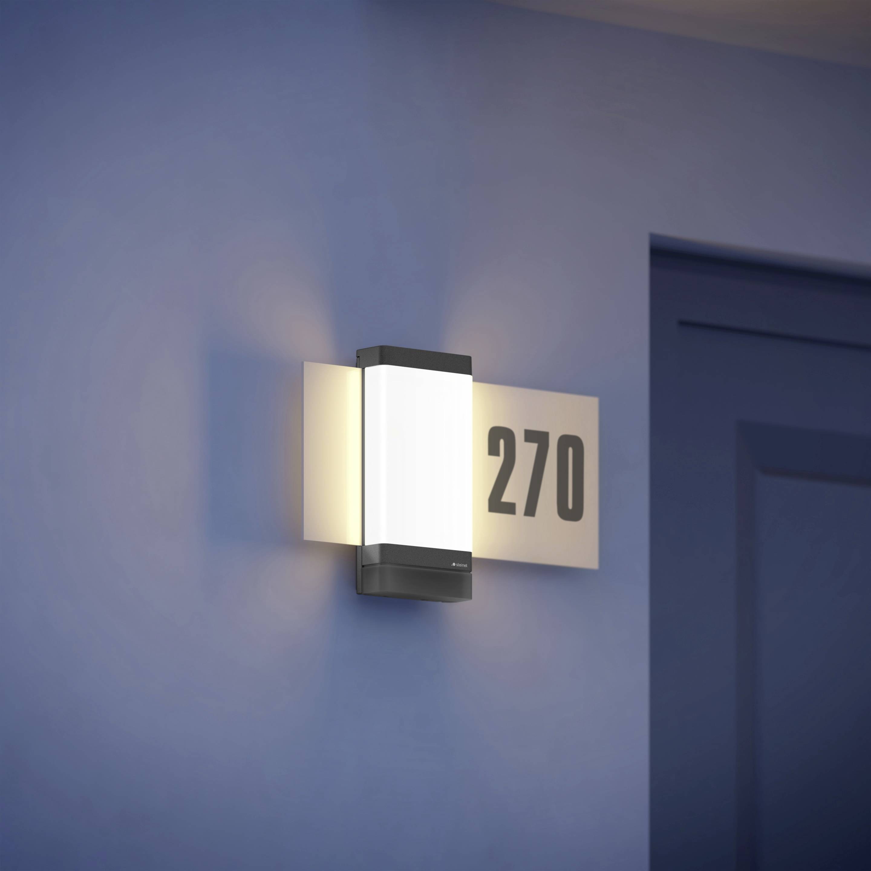 Außenlichtstrahler an einer blauen Wand, beleuchtet, mit der Zimmernummer '270' daneben.