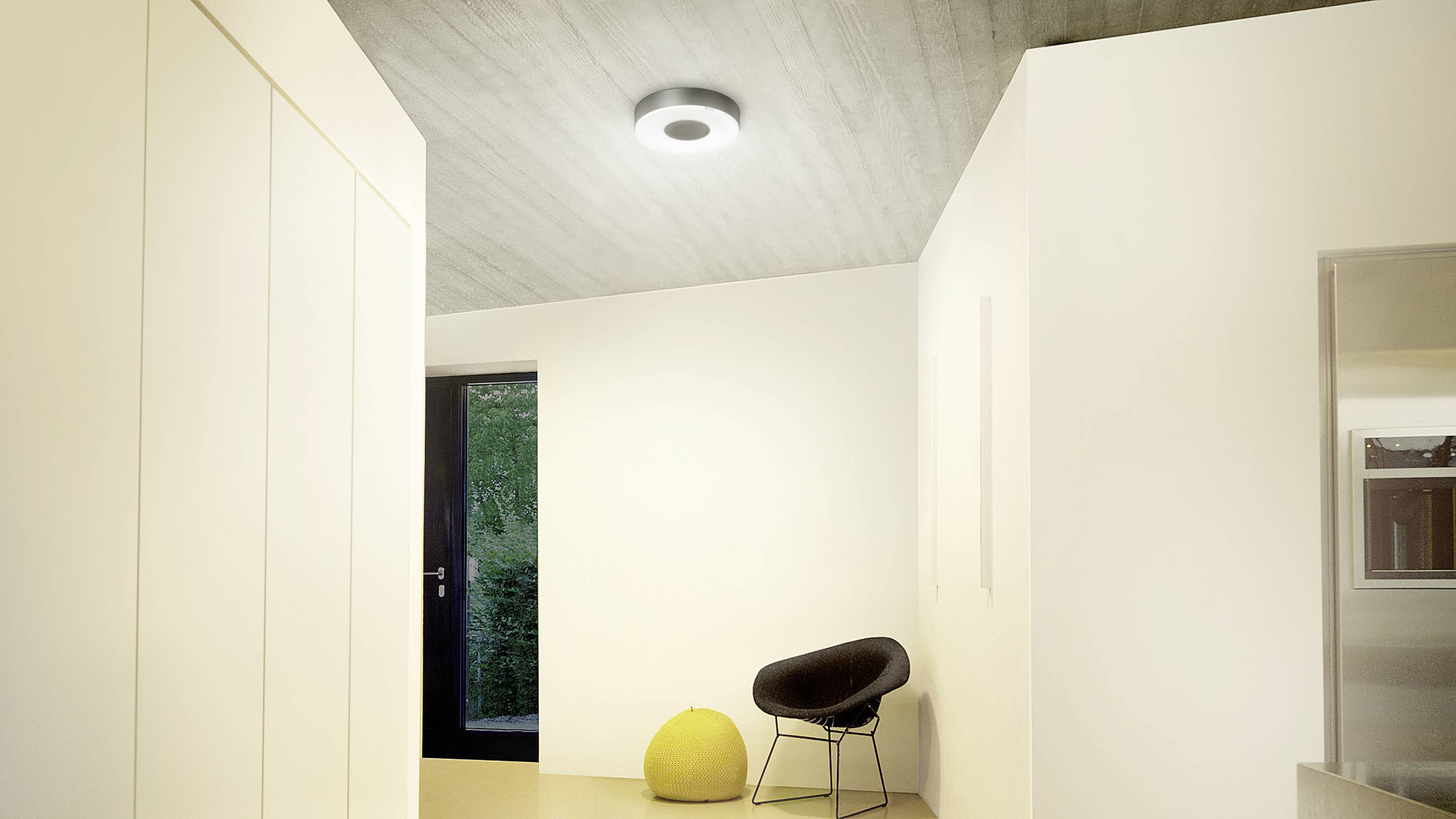 Ein modernes, minimalistisch eingerichtetes Zimmer mit einer schwarzen Tür, einem schwarzen Stuhl, einem gelben Hocker und einer Deckenleuchte.