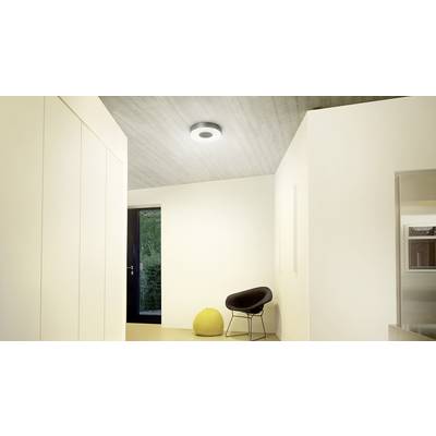 Ein modernes, minimalistisch eingerichtetes Zimmer mit einer schwarzen Tür, einem schwarzen Stuhl, einem gelben Hocker und einer Deckenleuchte.