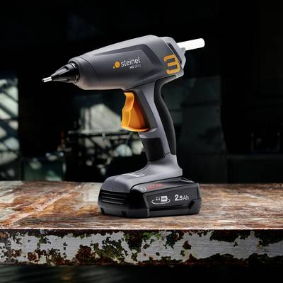 Kabellose Heißklebepistole mit ergonomischem Griff, platziert auf einer Werkbank. Im Hintergrund unscharfe Werkstattumgebung.