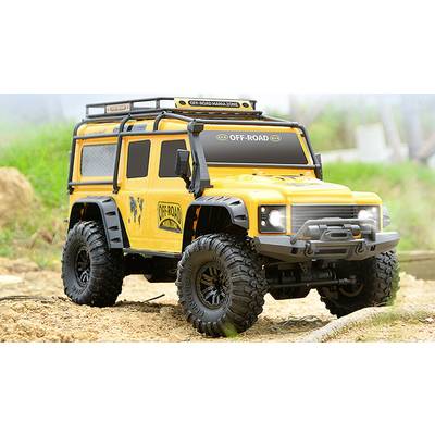 Gelbes ferngesteuertes Geländefahrzeug mit Aufschrift 'OFF-ROAD' steht auf sandigem Gelände, umgeben von Gras und Bäumen im Hintergrund.