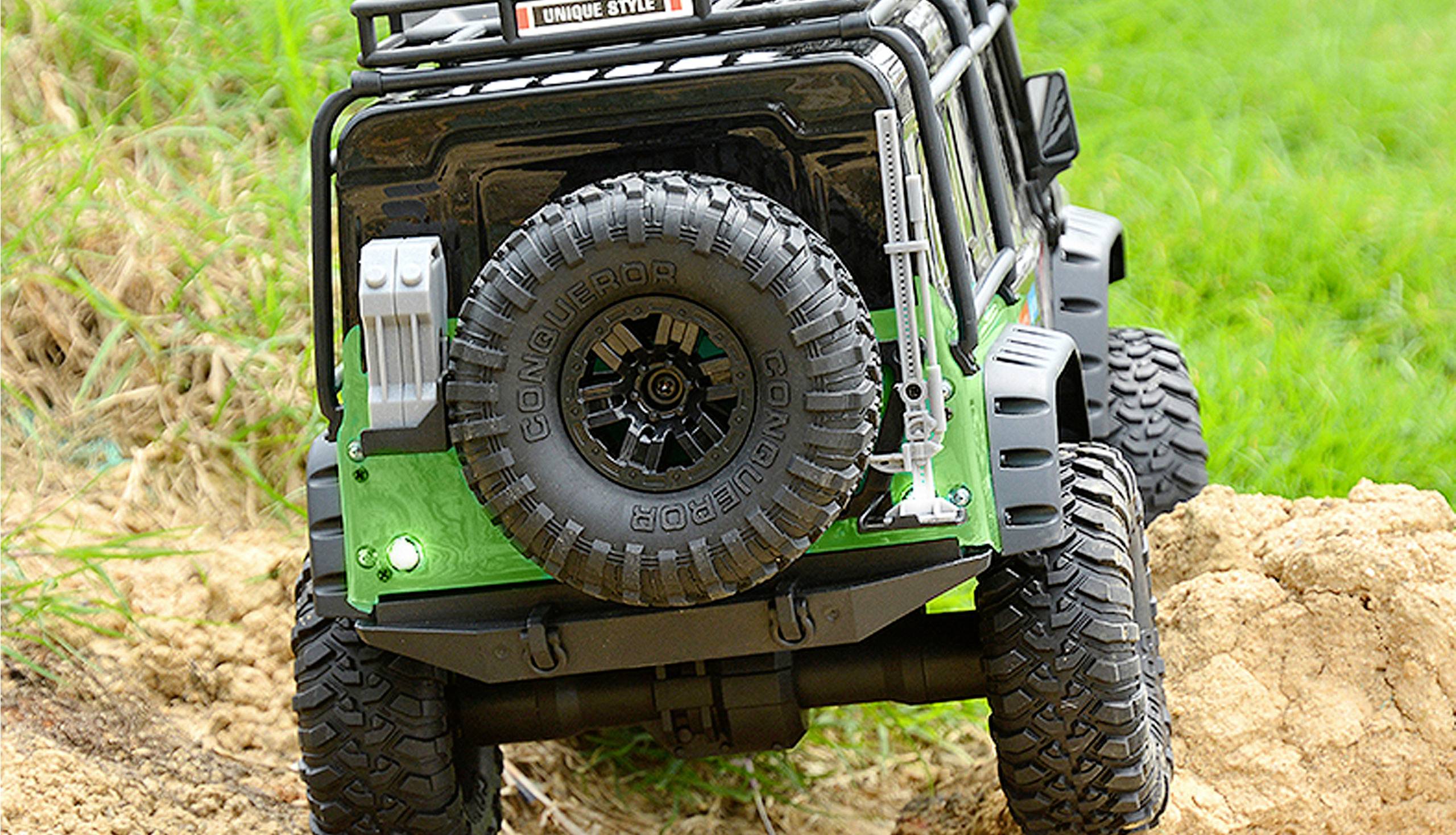 Ein Modellauto im Offroad-Design fährt über unwegsames Gelände. Der Fokus liegt auf den Reifen, die für schwierige Oberflächen geeignet sind.