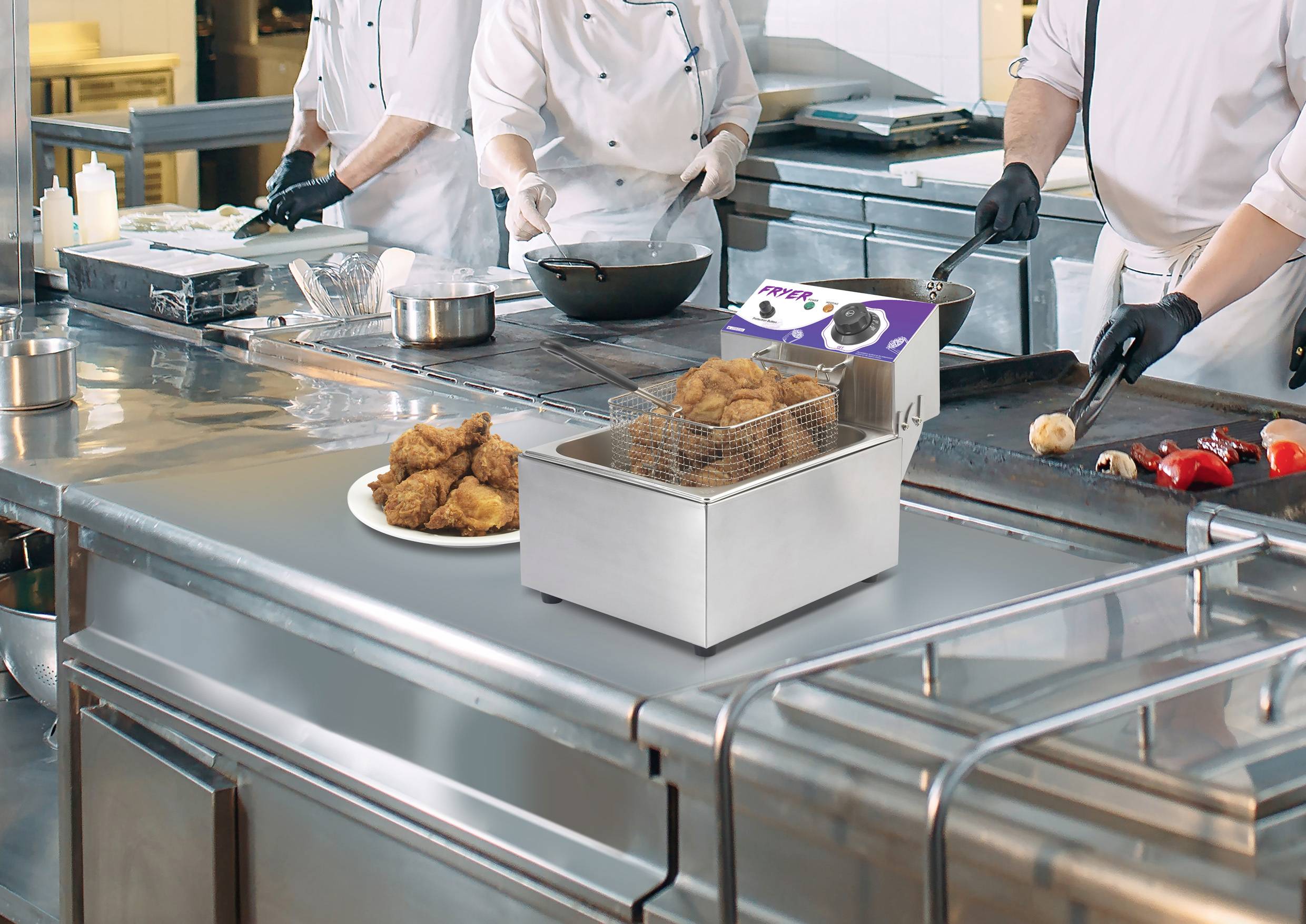 Köche in einer professionellen Küche bereiten Gerichte zu. Im Vordergrund steht eine Fritteuse mit frittiertem Essen auf einem Tisch.