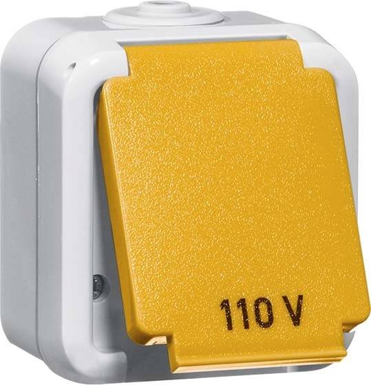 Ein gelber Schutzschaltergehäuse mit der Aufschrift '110 V', montiert auf einem weißen, rechteckigen Gehäuse.