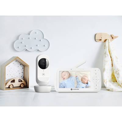Überwachungskamera und Monitor zeigen schlafende Babys. Kameraset auf weißem Tisch mit Wolken- und Hausdekoration im Hintergrund.