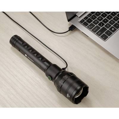 Eine schwarze Taschenlampe wird über ein USB-Kabel mit einem Laptop verbunden, auf einem Holztisch liegend.