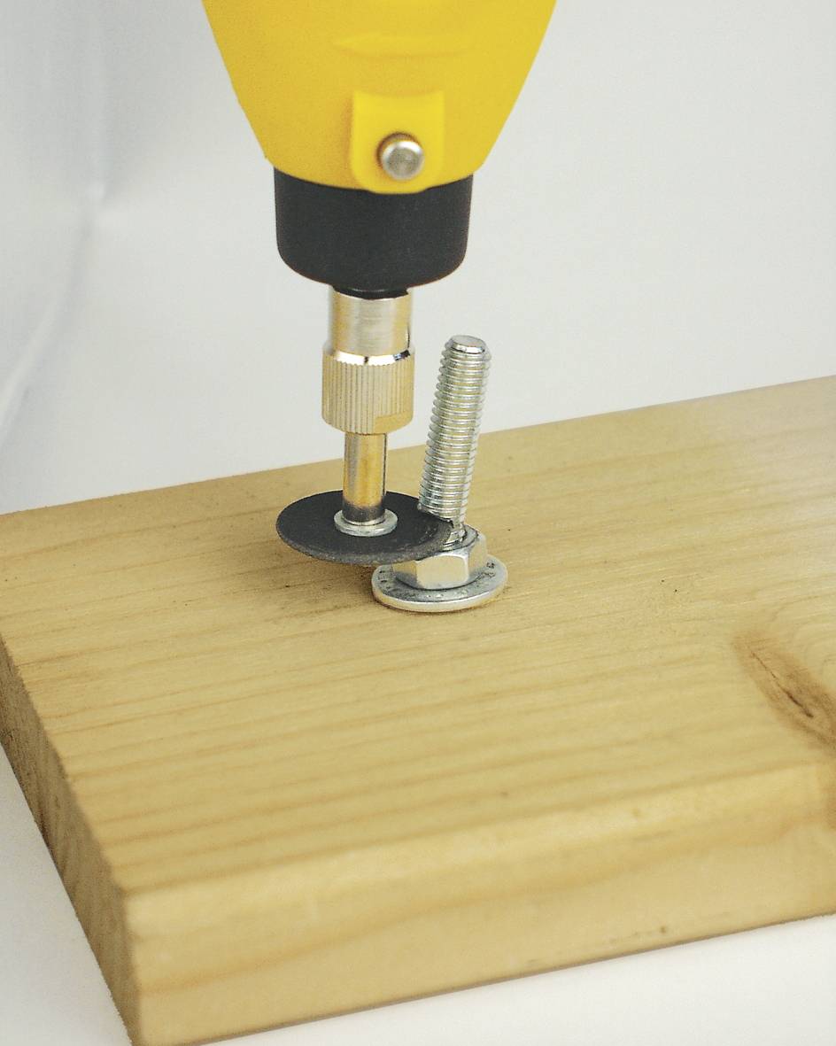 Eine gelbe Bohrmaschine zieht eine Schraube in ein Holzbrett, wobei ein schwarzer Einsatz verwendet wird.