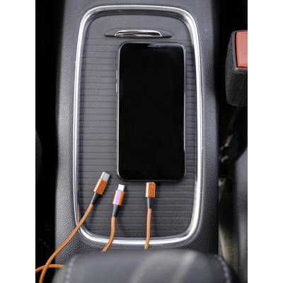 Smartphone liegt in einer Autoablage neben orangefarbenen Ladekabeln mit verschiedenen Anschlüssen.