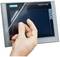 Hand entfernt Schutzfolie von einem SIMATIC HMI Touchdisplay.