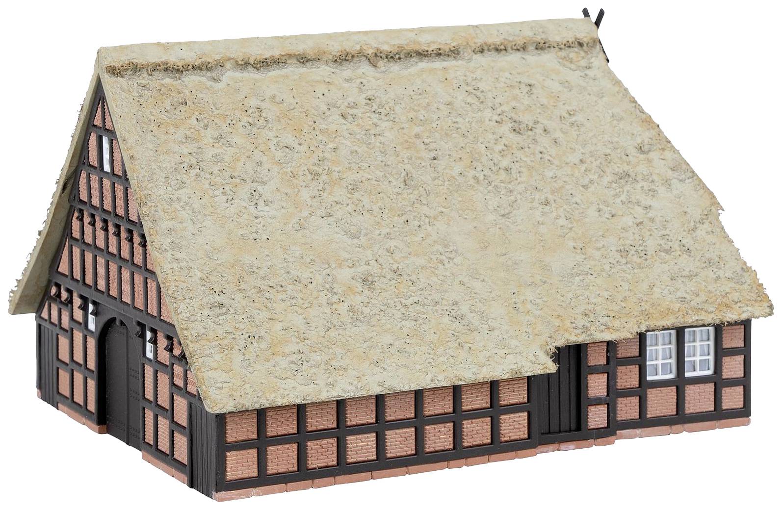 Ein traditionelles Fachwerkhaus mit Reetdach. Die Wände sind aus rotem Ziegelstein mit Holzverzierungen, und das Dach wirkt alt und naturbelassen.