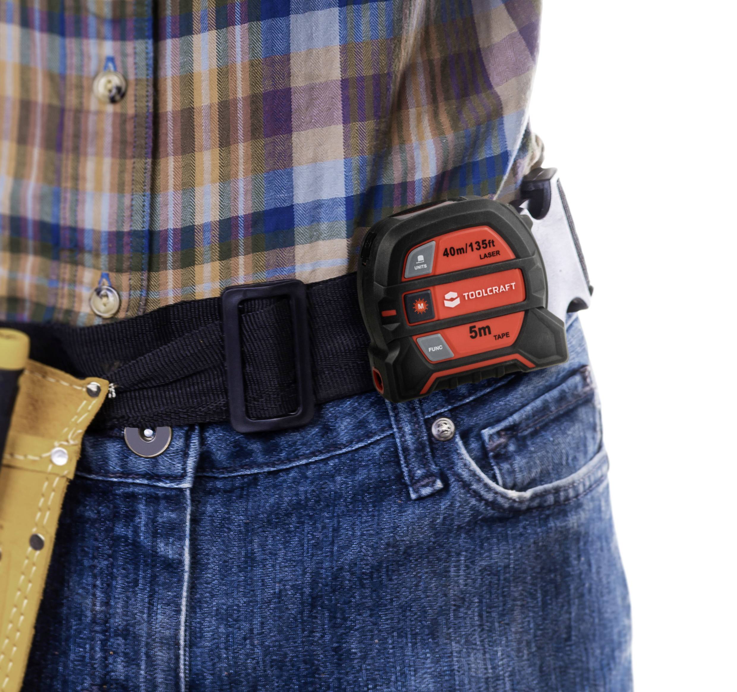 'Mann in karierter Hemd und Jeans trägt ein Maßband am Gürtel. Das Maßband hat eine Reichweite von 40 m/135 ft.'