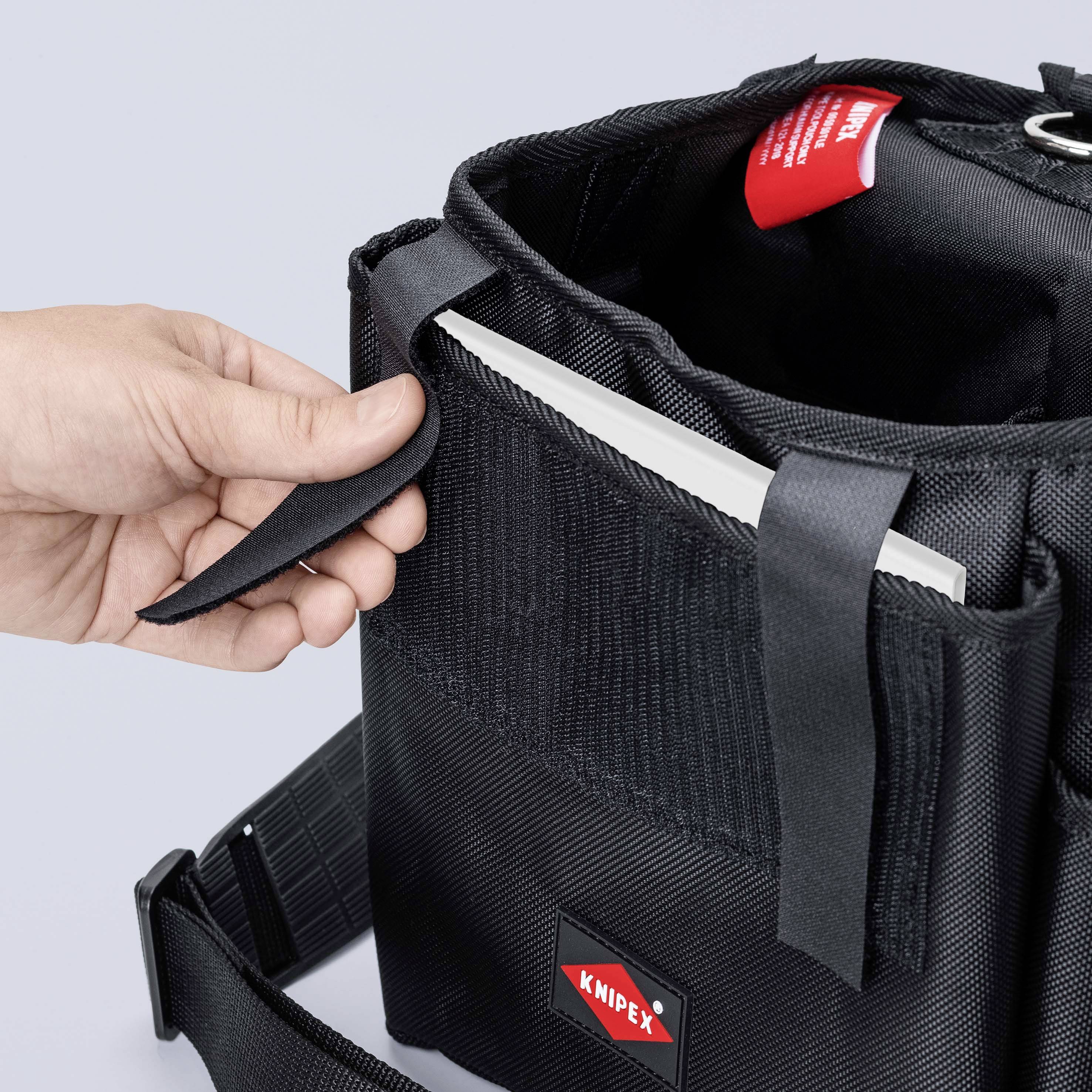 Person hält eine schwarze Werkzeugtasche von Knipex, teilweise geöffnet, zeigt ein Fach mit eingelegtem Detail.