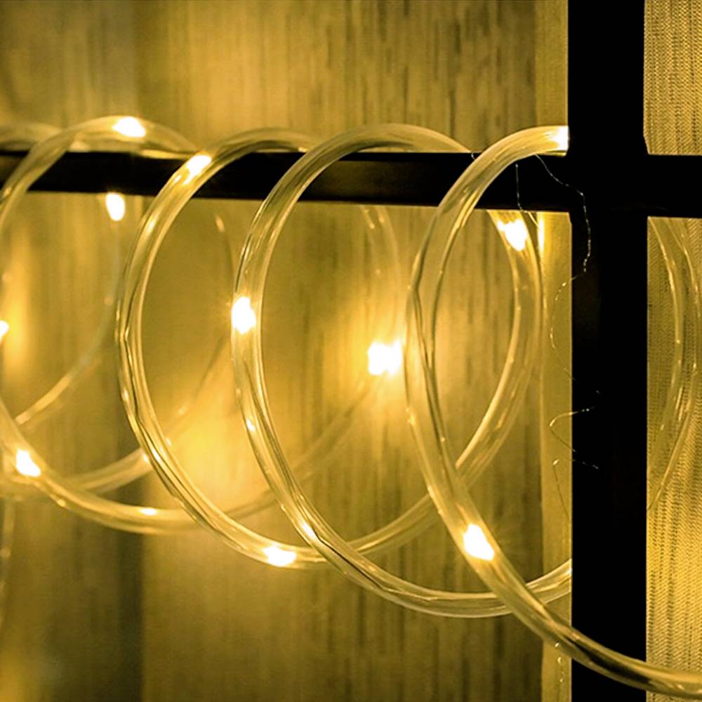 Eine Lichterkette mit warmweißen Lichtern ist auf einem dunklen Hintergrund aufgehängt und sorgt für eine gemütliche Atmosphäre.