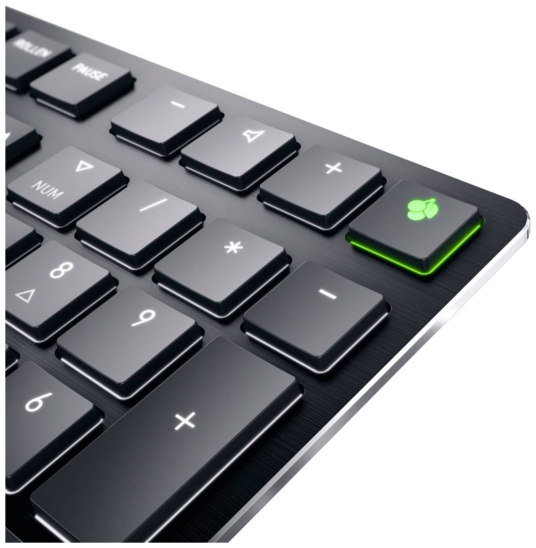 Schwarze Tastatur mit einem grünen Blatt auf der Num-Lock-Taste, symbolisiert ökologische Nachhaltigkeit oder umweltfreundliches Design.