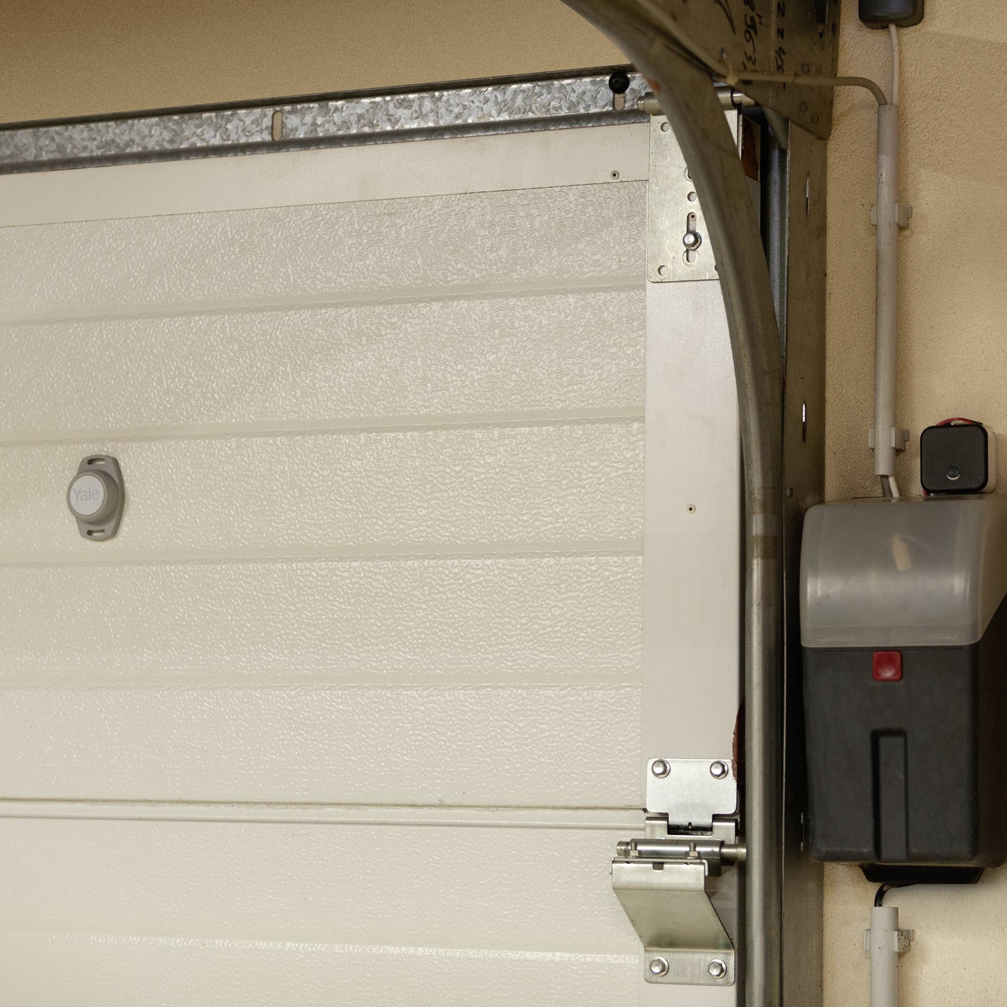 'Garagentor' zeigt einen abgeschnittenen Ausschnitt eines Garagentors mit mechanischem Öffnungsgerät.