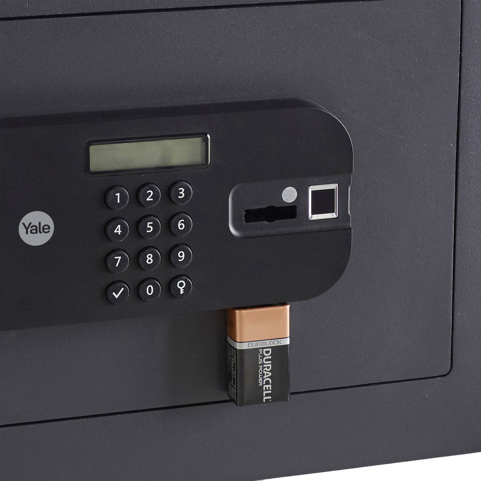 Tresor mit elektronischem Zahlenschloss und Fingerabdruckscanner, daneben offenliegender Batteriefach mit Duracell-Batterien.