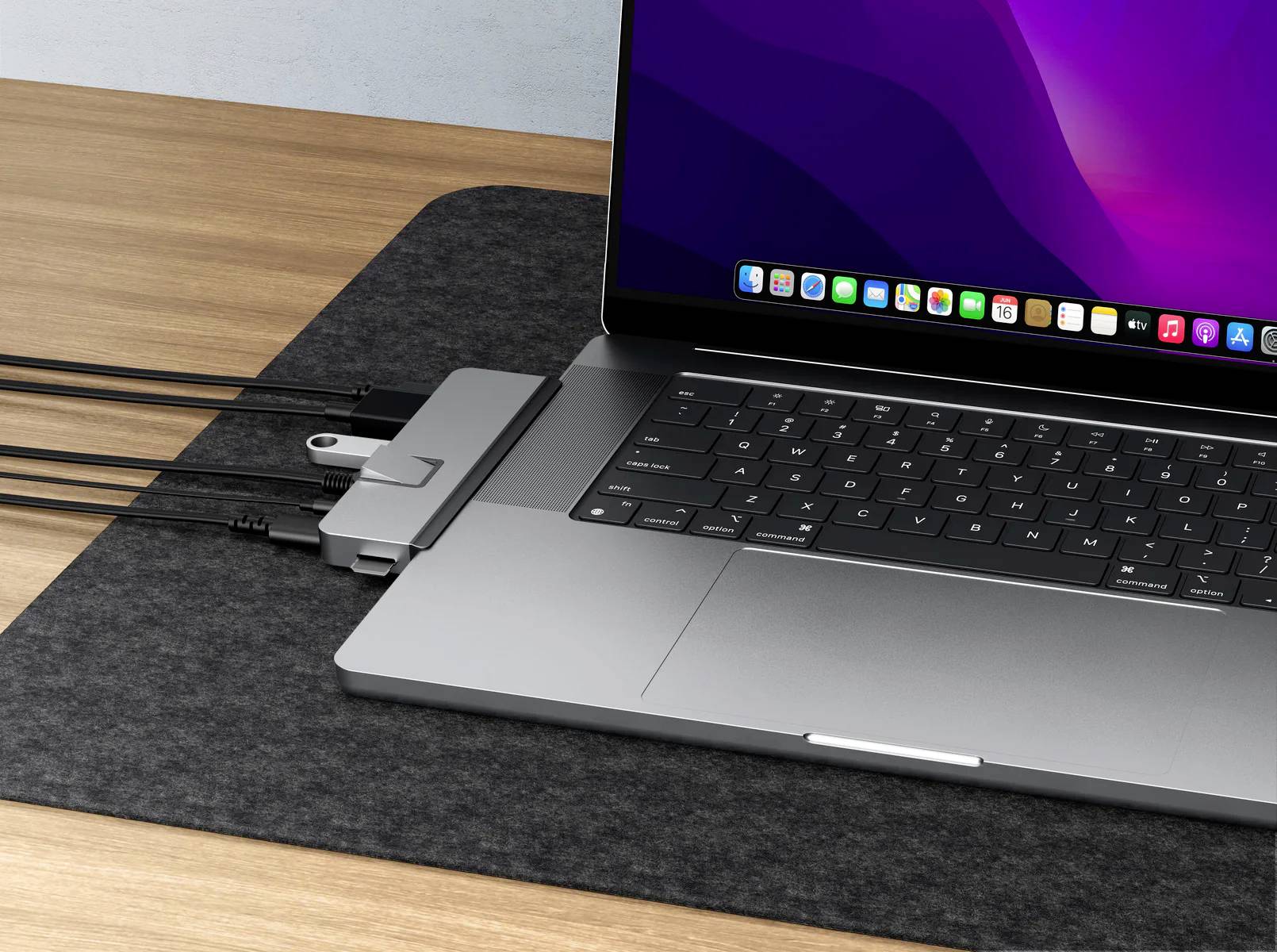 Ein aufgeklappter Laptop mit angeschlossenem USB-C-Hub, der mehrere Kabel verbindet. Der Bildschirm zeigt bunte Symbole.