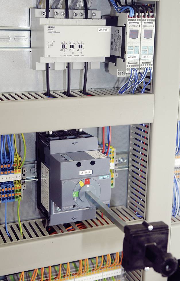 Elektrischer Schaltschrank mit einem Hauptschalter und mehreren Kabeln, die an verschiedene Komponenten angeschlossen sind.