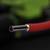 Ein rotes Kabel, das einen silbernen, metallischen Innenleiter zeigt, vor unscharfem, dunklem Hintergrund.