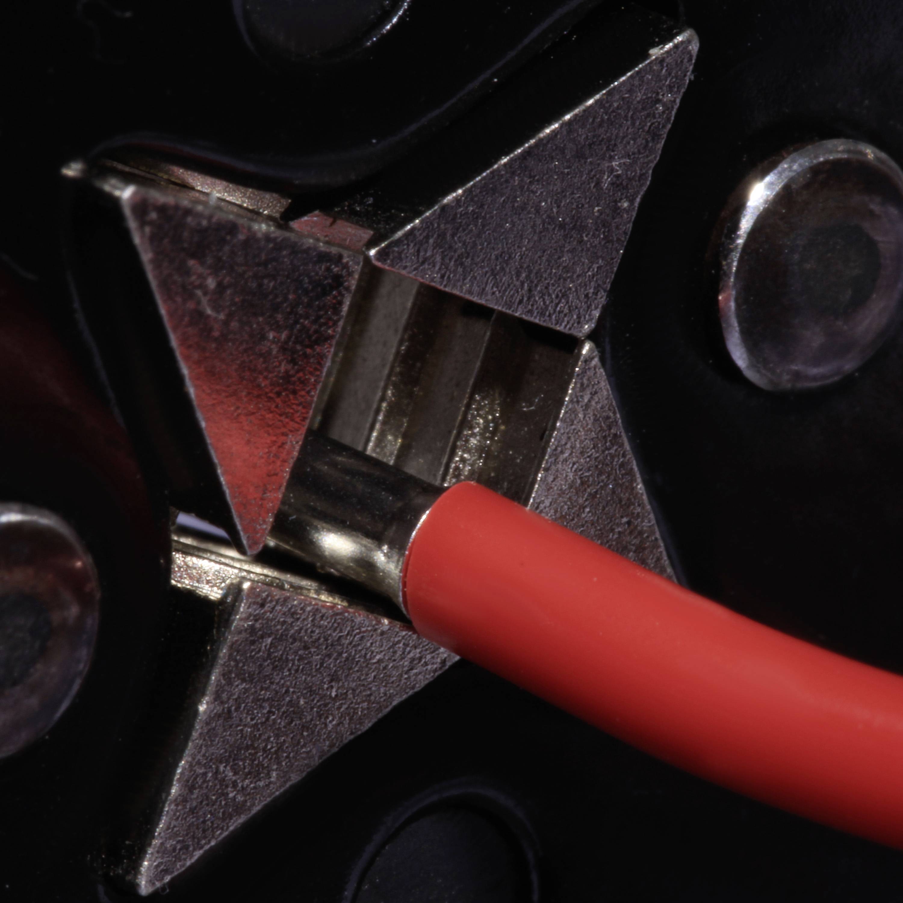 Rotes Kabel, das an einen silbernen, sternförmigen Anschluss angeschlossen ist, mit schwarzem Hintergrund und Metallkomponenten.