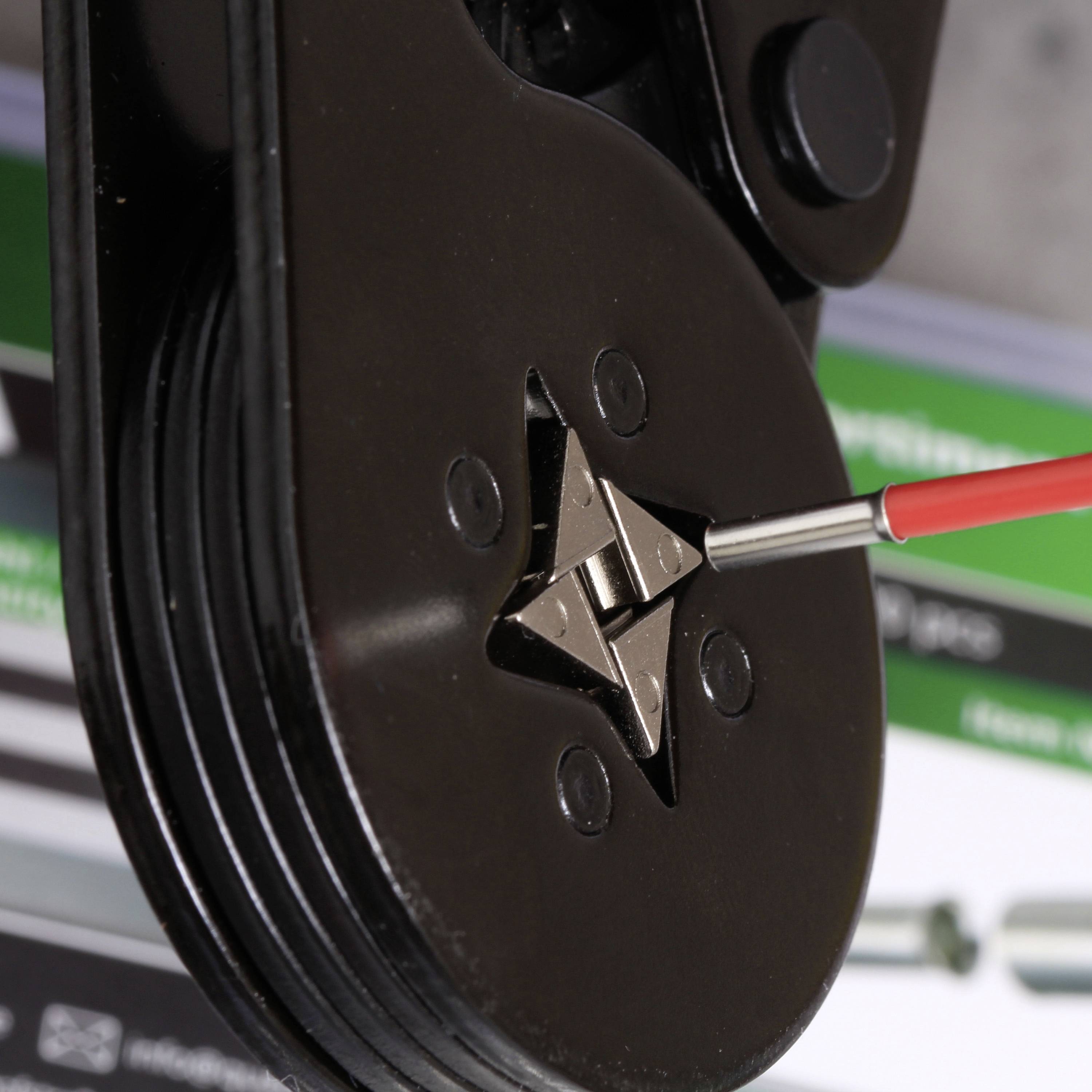 Nahaufnahme eines Crimpwerkzeugs, das einen elektrischen Stecker presst. Zeigt präzises Arbeiten an technischen Komponenten.