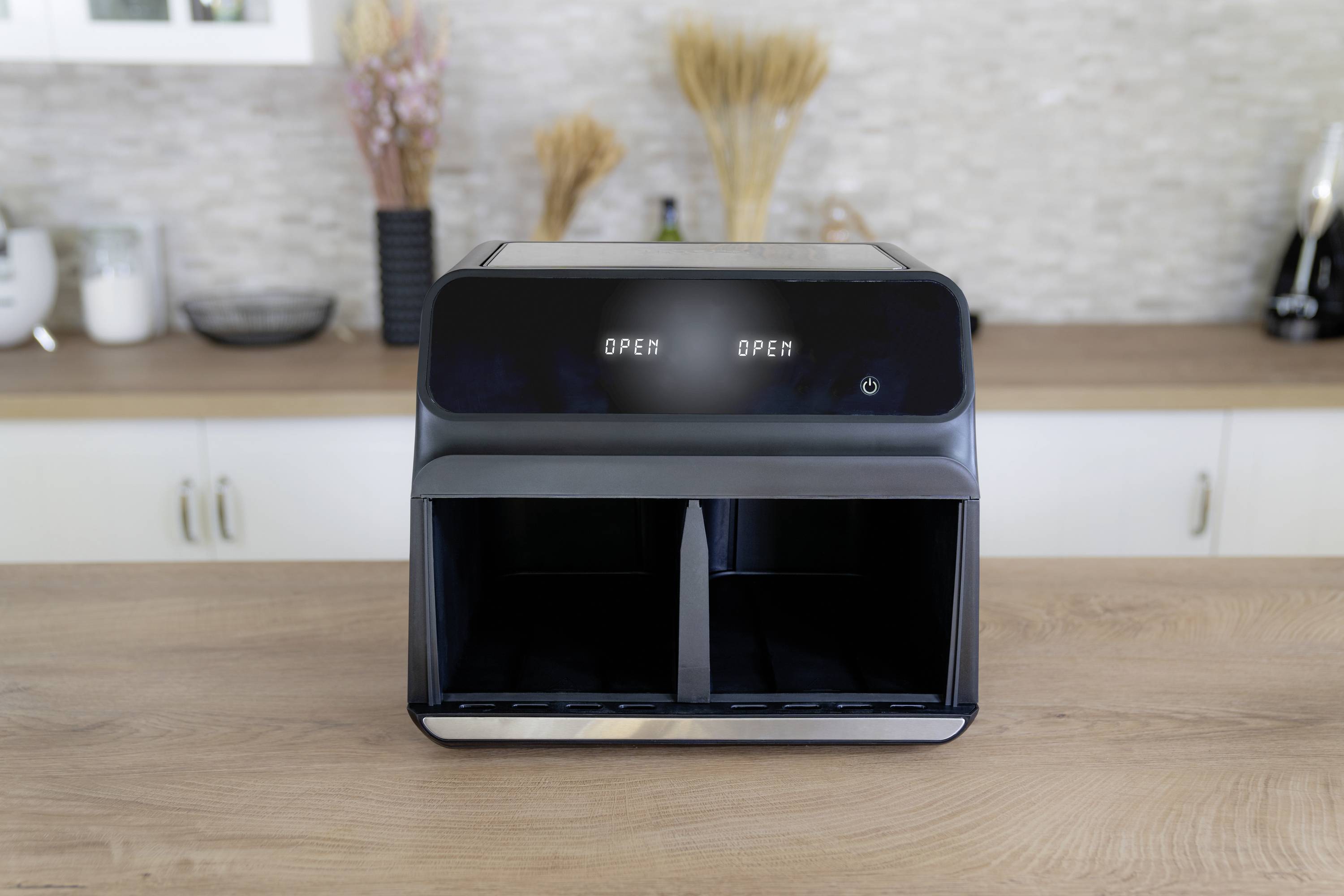 Ein moderner zweifacher Brotschneider steht auf einer Küchenarbeitsplatte. Auf dem Display steht 'Open' über beiden Fächern.
