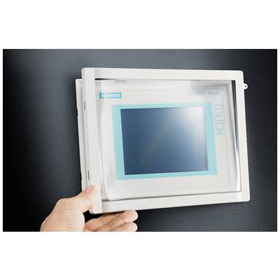 Eine Hand öffnet die Schutzabdeckung eines Siemens SIMATIC Touch Panels an der Wand.
