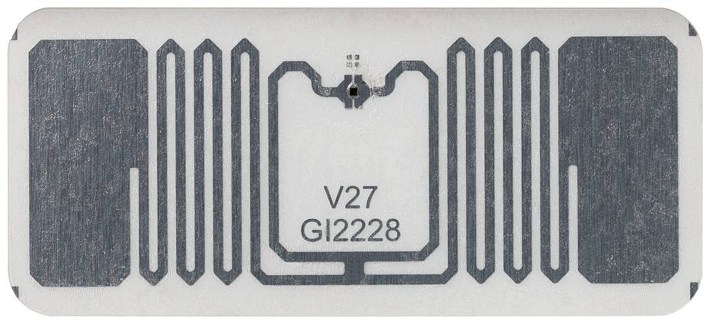 Ein RFID-Chip mit der Aufschrift 'V27 G12228' in der Mitte, umgeben von Antennenelementen auf einer rechteckigen Oberfläche.