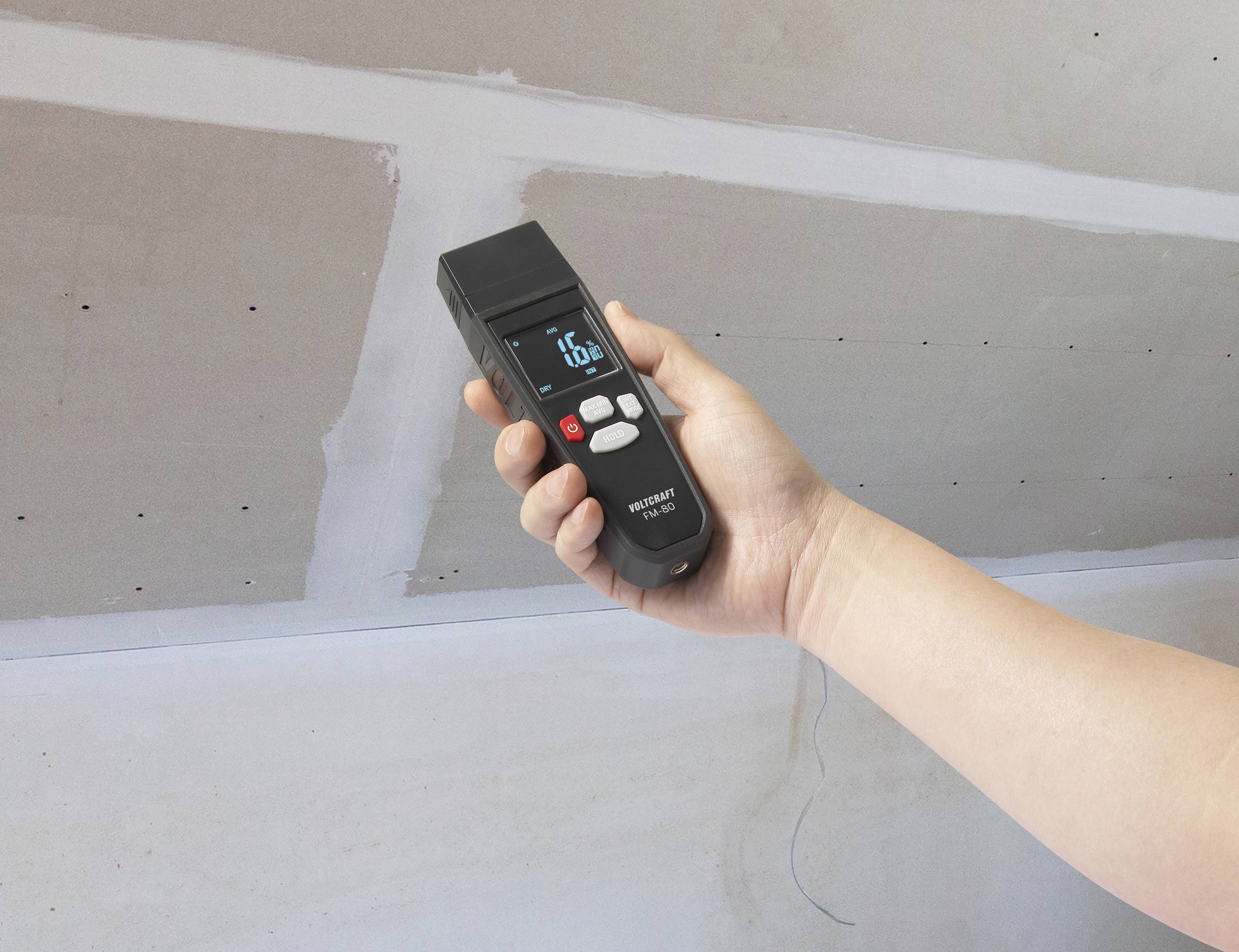 Hand, die ein digitales Messgerät für Entfernungen gegen eine weiße Decke hält. Gerät zeigt '1.5m' an.