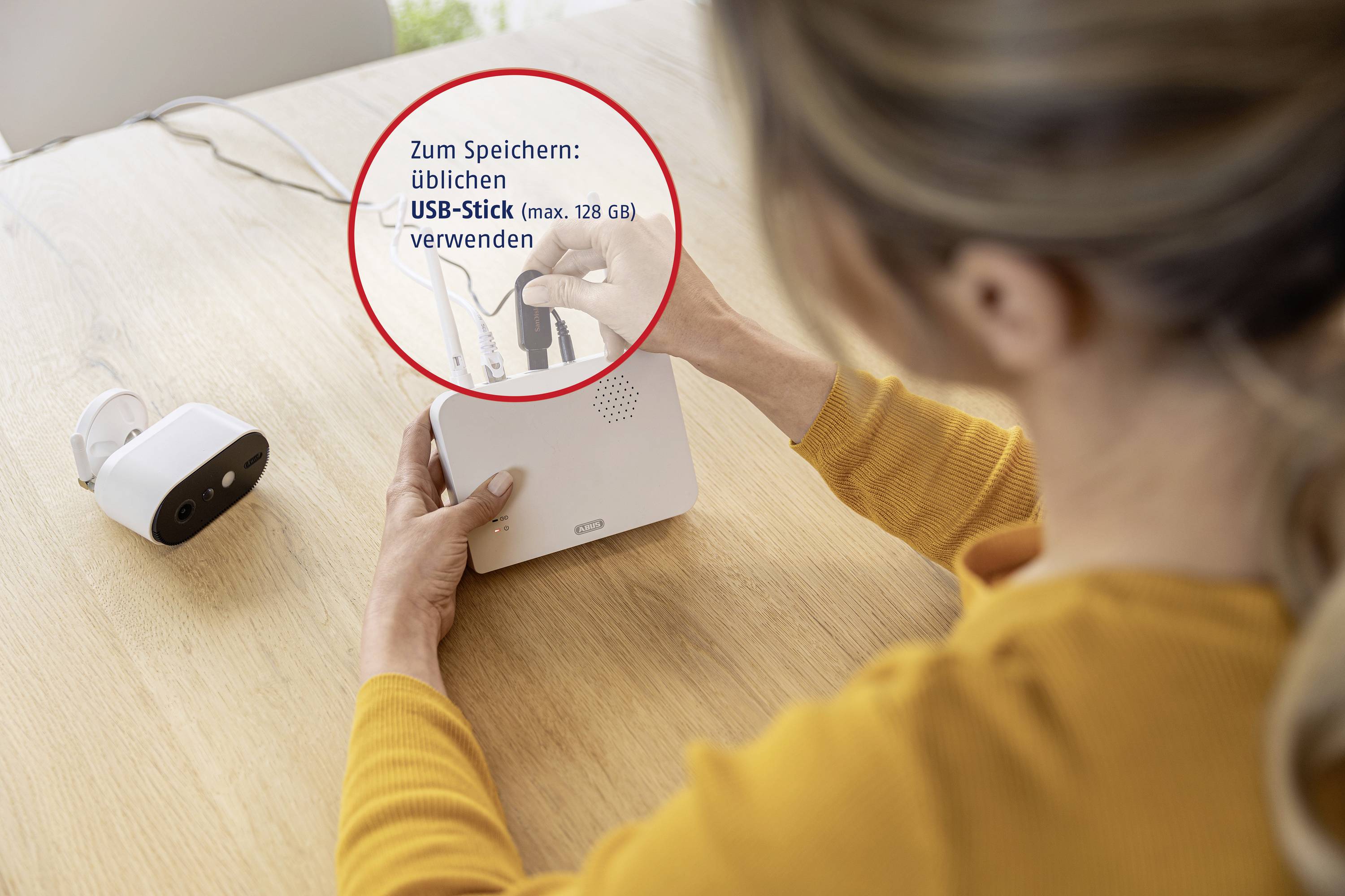 Eine Person steckt einen USB-Stick in ein Gerät ein. Text im Bild weist darauf hin, dass ein 'üblichen USB-Stick (max. 128 GB)' verwendet wird.