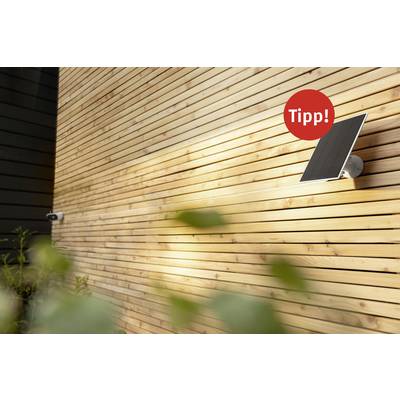 Solarmodul an einer hölzernen Wand, sonnig beleuchtet, mit einem roten Kreis und dem Wort 'Tipp!' darauf.