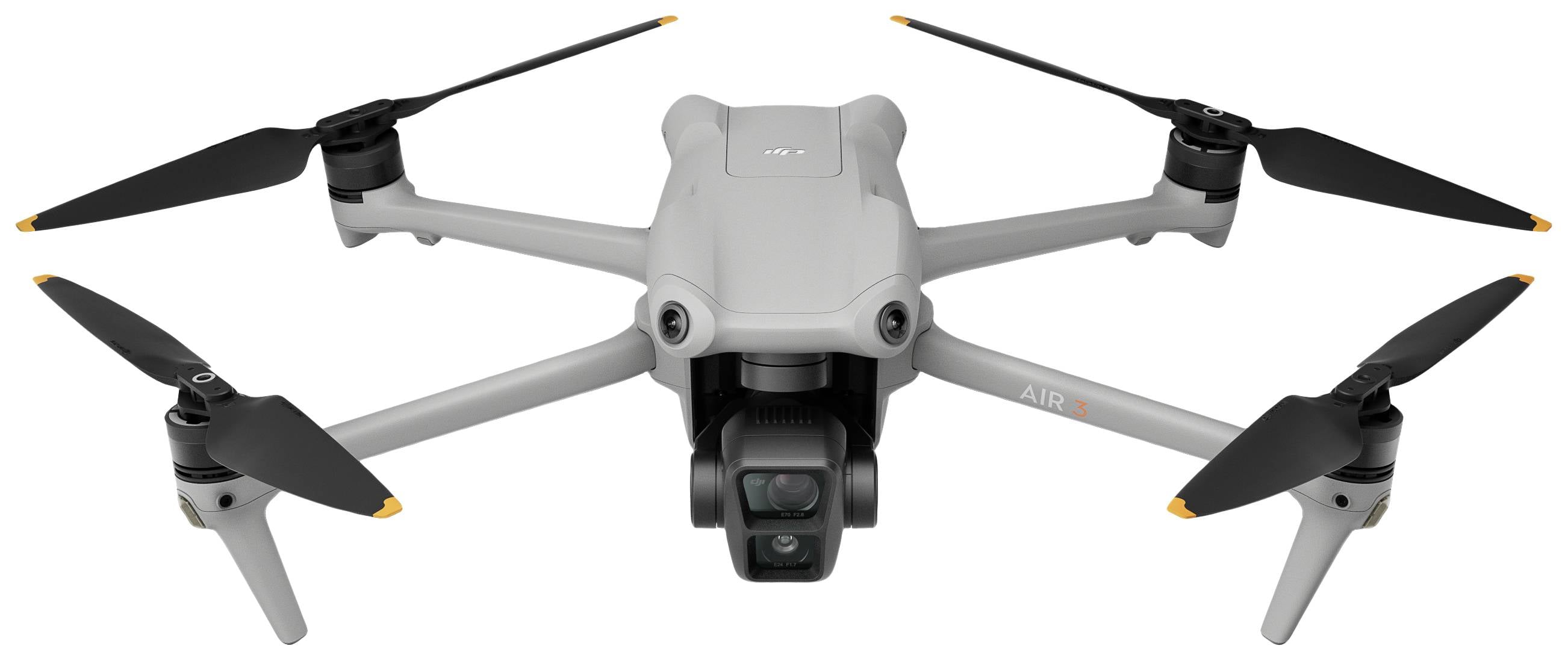 Eine graue Drohne mit vier Rotoren und Kamera vorne, auf weißem Hintergrund. Sie ist flugbereit positioniert und zeigt technisches Design.