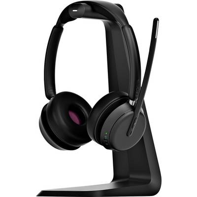 Schwarzes kabelloses Headset auf einem Ständer. Ein grünes Licht leuchtet an einer Ohrmuschel. Das Headset hat ein Mikrofon.