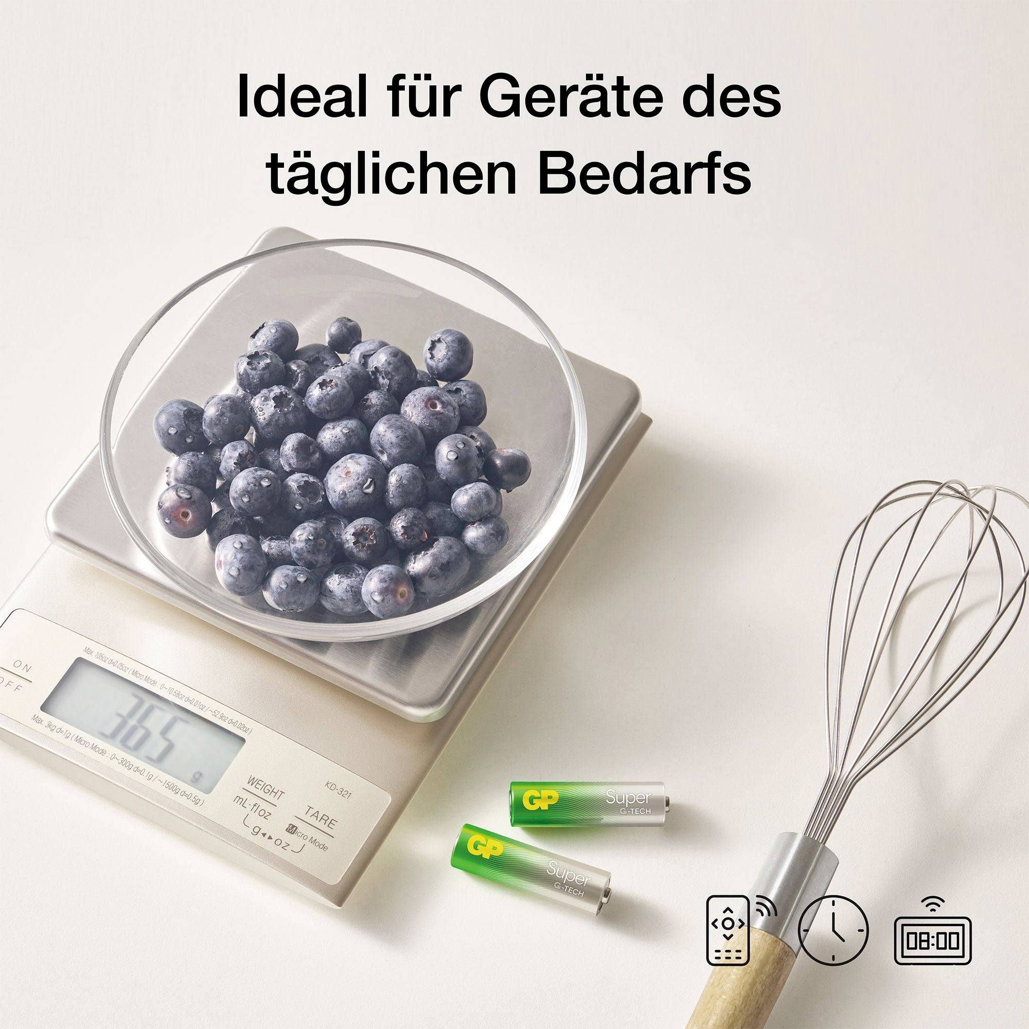 Küchenwaage mit Schale voller Blaubeeren, daneben zwei Batterien und ein Schneebesen; Text: 'Ideal für Geräte des täglichen Bedarfs'.